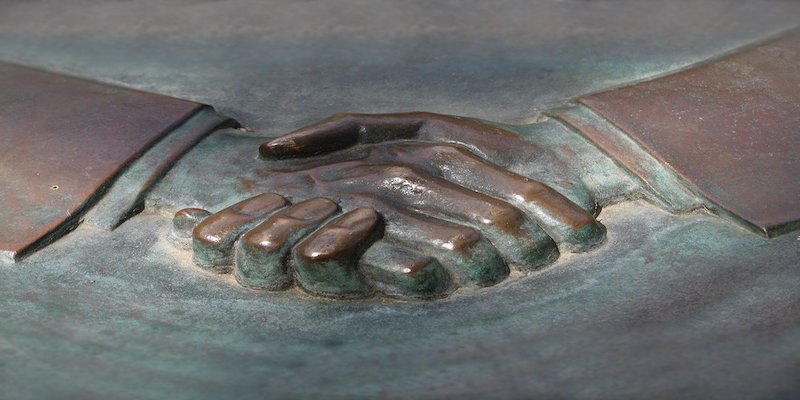 handshake carved in metal