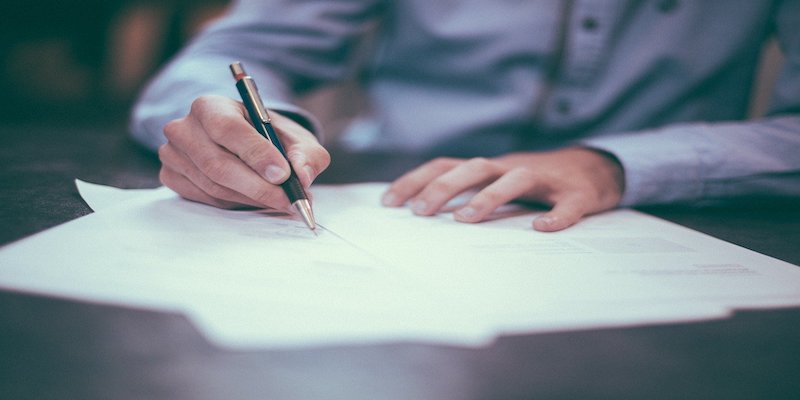 man signing document