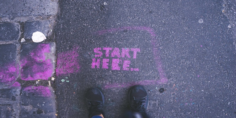 start here sign spray painted on pavement